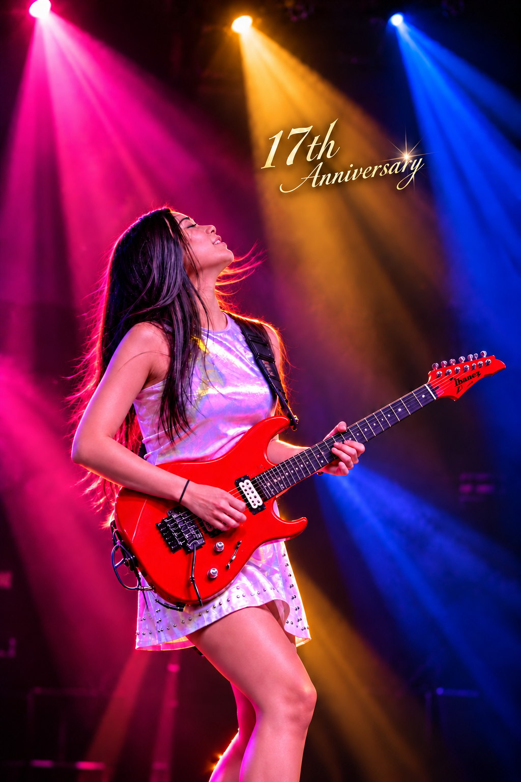 Petch with a red guitar under pink, gold and blue stage lights, with 17th Anniversary lettering